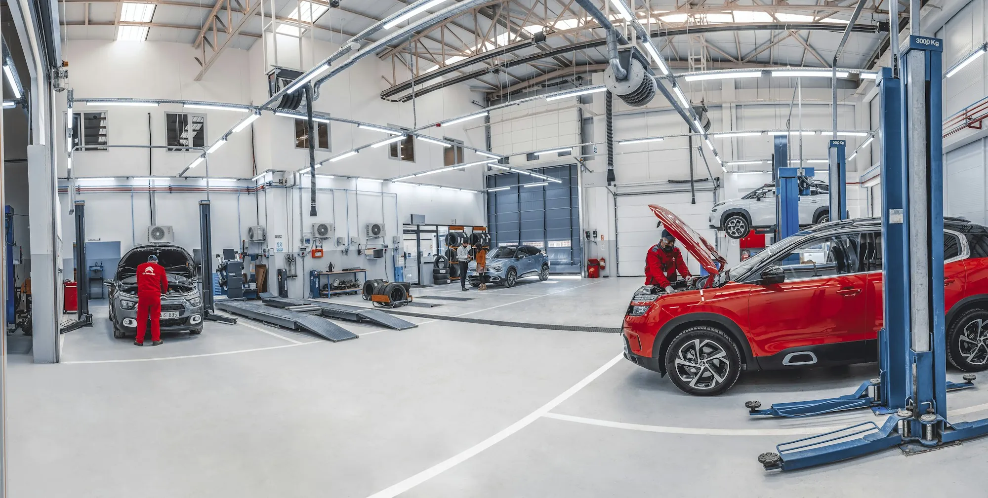 Technician working on a bare aluminum truck door panel in a separated repair area