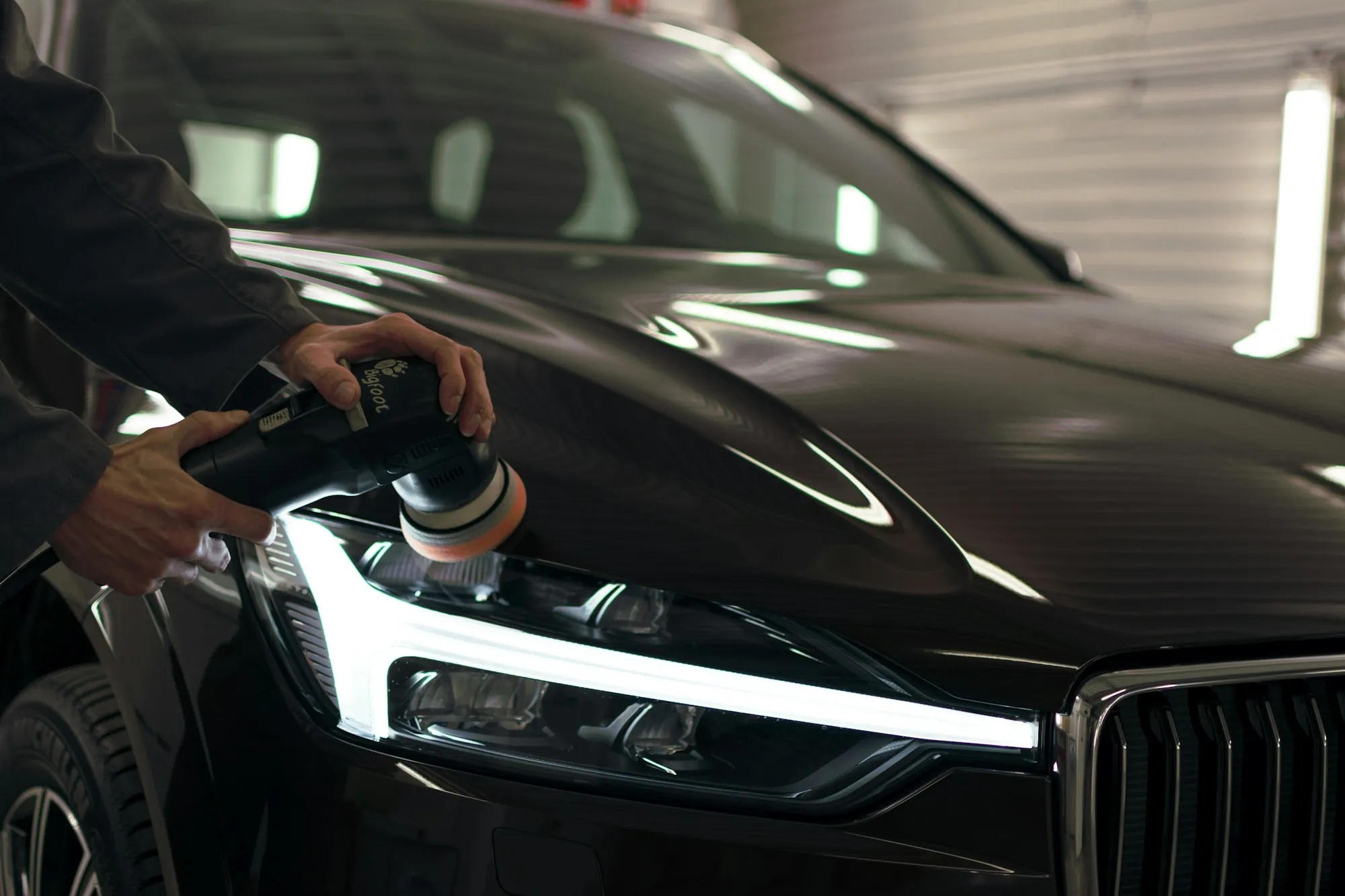 Technician polishing a car's headlight