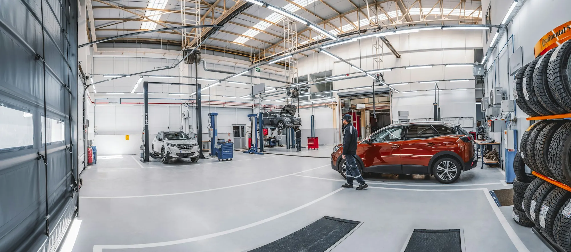 Bright repair shop with vehicles on lifts